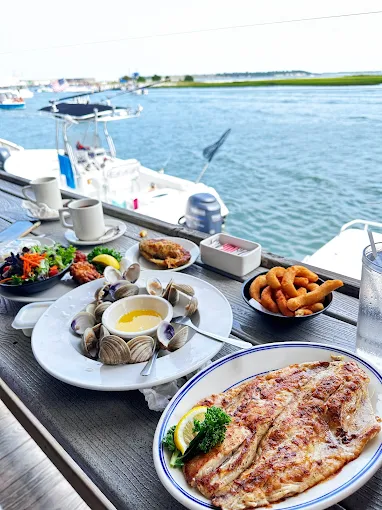 plate of seafood sitting on waterfront table with a view of the harbor
